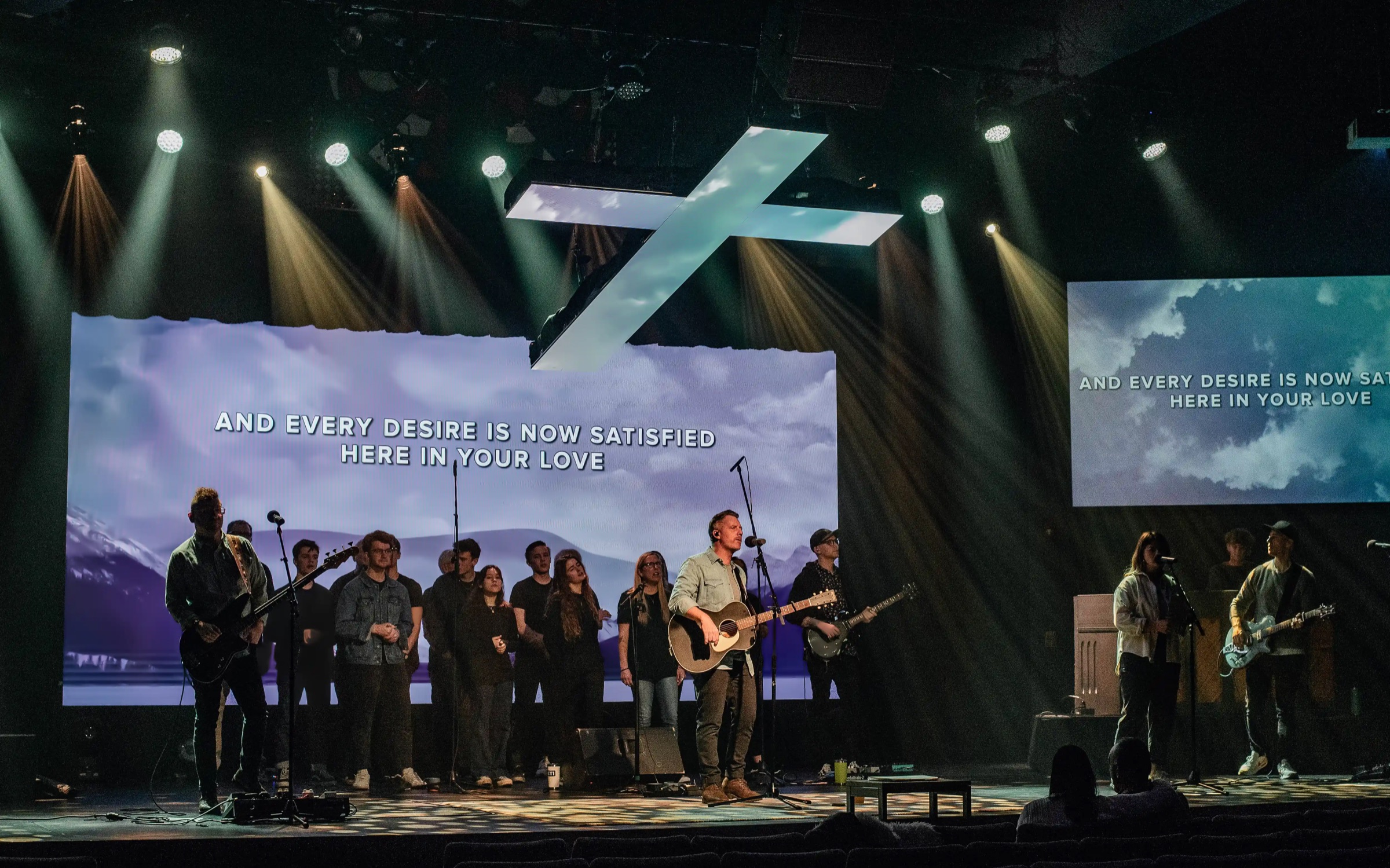 Worship band leading an Easter service under a cross with Altitude LED screens