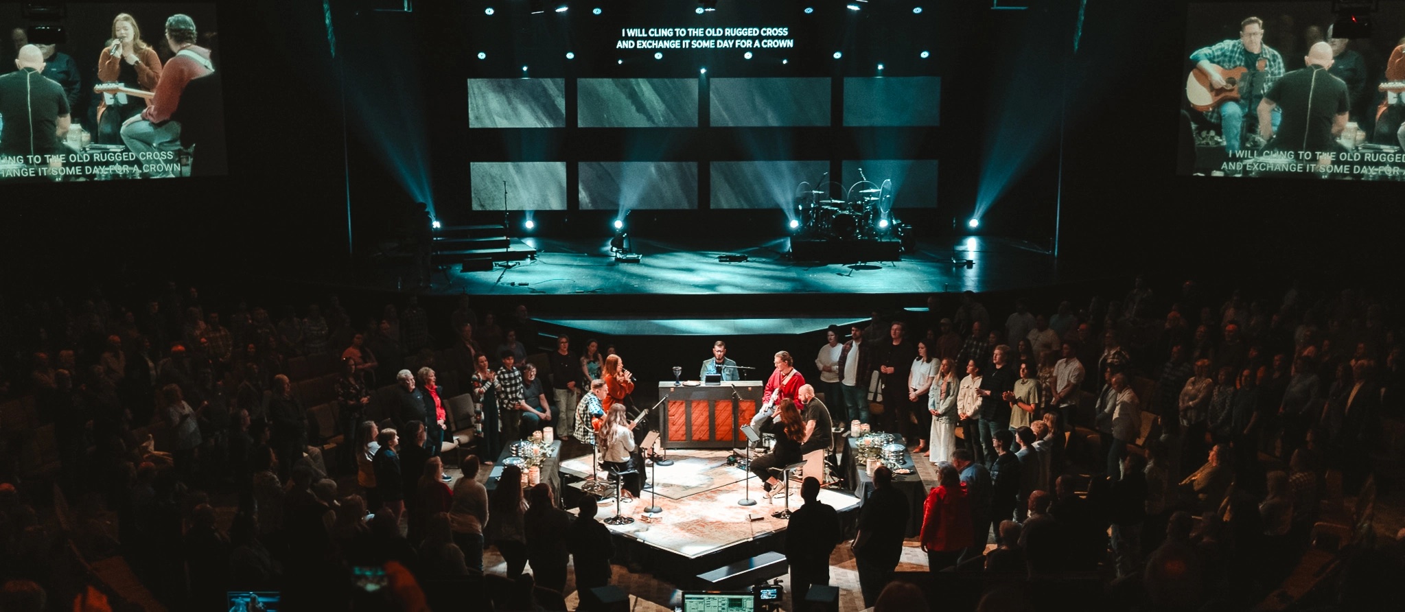 Packed church auditorium with suspended Altitude LED panels over the stage